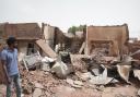A man walks past a destroyed home in Khartoum