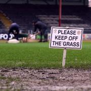 Ground staff work away on the pitch at Dens Park