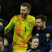 Andy Robertson, right, and Angus Gunn, centre, try to fire up their Scotland team mates during the national anthem at Hampden on Tuesday evening