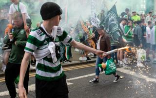 A Celtic fans sets off a flare during a street party in Glasgow city centre after the Parkhead club's Scottish title win last year