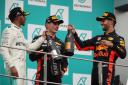 Race winner Max Verstappen of Netherlands and Red Bull Racing, second place finisher Lewis Hamilton of Great Britain and Mercedes GP and third place finisher Daniel Ricciardo of Australia and Red Bull Racing celebrate on the podium during the Malaysia For