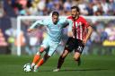 SOUTHAMPTON, ENGLAND - OCTOBER 07:  Eden Hazard of Chelsea runs with the ball under pressure from Manolo Gabbiadini of Southampton during the Premier League match between Southampton FC and Chelsea FC at St Mary's Stadium on October 7, 2018 in Southam