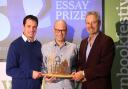 Winner of the 2023 Anne Brown Essay Prize Rodge Glass (centre) is presented with his award by Adrian Turpin (left), Creative Director of the Wigtown Book Festival and broadcaster and author Gavin Esler