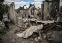TOPSHOT - Ivan Sosnin, 19, walks next to his destroyed house in the city of Lysychansk at the eastern Ukrainian region of Donbas on June 7, 2022. (Photo by ARIS MESSINIS / AFP) (Photo by ARIS MESSINIS/AFP via Getty Images).