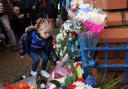 A young Rangers fan lays flowers in memory of the 66 fans who lost their lives in the 1971 Ibrox disaster