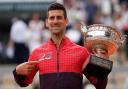 Novak Djokovic points to the 23 on his jacket as he holds the French Open trophy (Thibault Camus/AP)