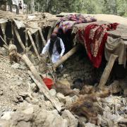 An Afghan villager collects his belongings from under the rubble of his home that was destroyed in an earthquake in the Spera District of the southwestern part of Khost Province, Afghanistan, Wednesday, June 22, 2022. A powerful earthquake struck a