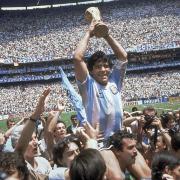 Diego Maradona holds up his team's trophy after Argentina's 3-2 victory over West Germany at the World Cup final soccer match at Atzeca Stadium in Mexico City. (AP Photo/Carlo Fumagalli, File).