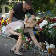 People lay floral tributes to the victims of the Russian rocket attack at a shopping center in Kremenchuk, Ukraine, Wednesday, June 29, 2022. (AP Photo/Efrem Lukatsky)