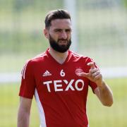 Graeme Shinnie has signed a three-year deal with Aberdeen after leaving Wigan Athletic