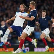 Scotland defender Ryan Porteous, right, tries to tackle England captain Harry Kane at Hampden tonight