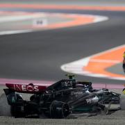 Lewis Hamilton stands next to his damaged Mercedes after his first-corner crash in Qatar (Darko Bandic/AP)