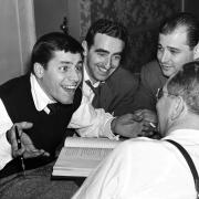Comedian Jerry Lewis, left, meets with Ed Simmons, center, writer Norman Lear, background right, and producer Ernie Glucksman for 