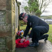 People lay wreaths before a remembrance service at Tundergarth Church to mark the 35th anniversary of the Lockerbie bombing