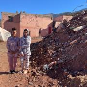 Fatima Zahra and Salma stand beside the ruins of their former home
