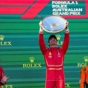 Ferrari driver Carlos Sainz of Spain holds his trophy aloft on the podium after winning the Australian Formula One Grand Prix at Albert Park, in Melbourne, Australia (Scott Barbour/AP)