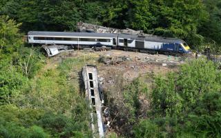 File photo dated 13/08/20  of emergency services inspecting the scene near Stonehaven, Aberdeenshire, following the derailment of the ScotRail train which cost the lives of three people. Prosecutors are considering whether Network Rail will face charges