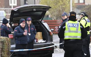 Locals hand out tea and coffee to police officers at the scene