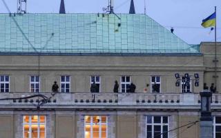 Police officers stand on the balcony of Philosophical Faculty of Charles University in downtown Prague, Czech Republic, Thursday, Dec. 21, 2023. Czech police say a shooting in downtown Prague has killed an unspecified number of people and wounded others