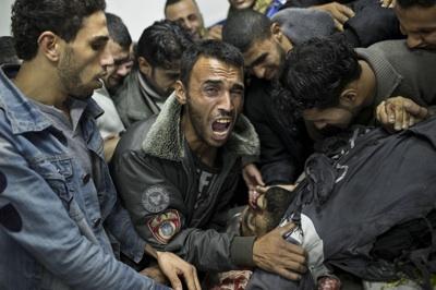 A Palestinian man cries next the body of a dead relative in the morgue of Shifa Hospital in Gaza City
