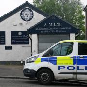A police vehicle sits outside of A. Milne funeral directors in Balornock, Glasgow.
