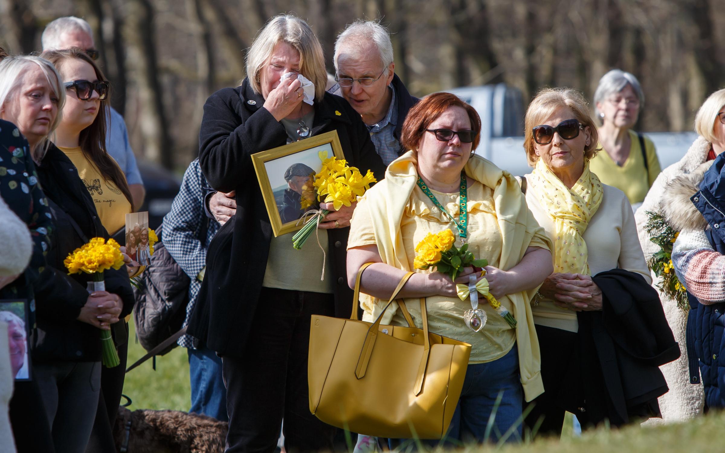 People pictured during a minutes silence for those lost to Covid at Riverside Grove in Pollok Country Park in Glasgow. Riverside Grove is the key focal point of The Heralds Covid memorial. Photograph by Colin Mearns.