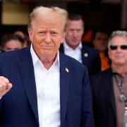 Republican presidential candidate and former President Donald Trump, left, gestures as he arrives at the Miami Formula One Grand Prix auto race Sunday, May 5, 2024, in Miami Gardens, Fla. (AP Photo/Rebecca Blackwell)