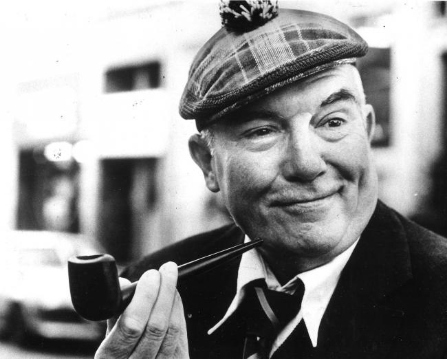Scots funnyman Chic Murray was pretending to puff on a pipe once owned by Sir Harry Lauder, which was being auctioned by Valda Grieve, the widow of Scottish writer Hugh MacDiarmid