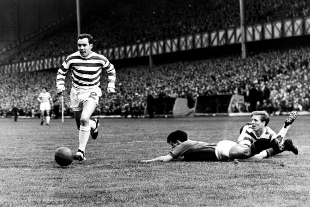 (L-R) Celtic's Duncan Mackay chases the ball as Rangers' Jim Forrest lies prostrate after being fouled by Celtic's Billy McNeill.