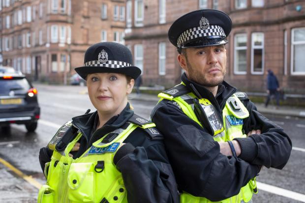 HeraldScotland: Sally Reid and Jordan Young as PC Sarah Fletcher and PC Jack McLaren in BBC comedy series Scot Squad. Picture: Martin Shields/The Comedy Unit/BBC