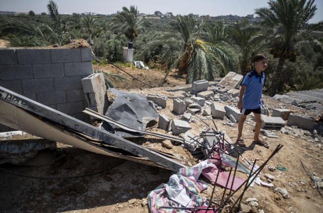 A Palestinian boy inspects the damage in his family home following Israeli airstrikes in Buriej refugee camp, central Gaza Strip, Saturday, Aug. 15, 2020. (AP Photo/Khalil Hamra).