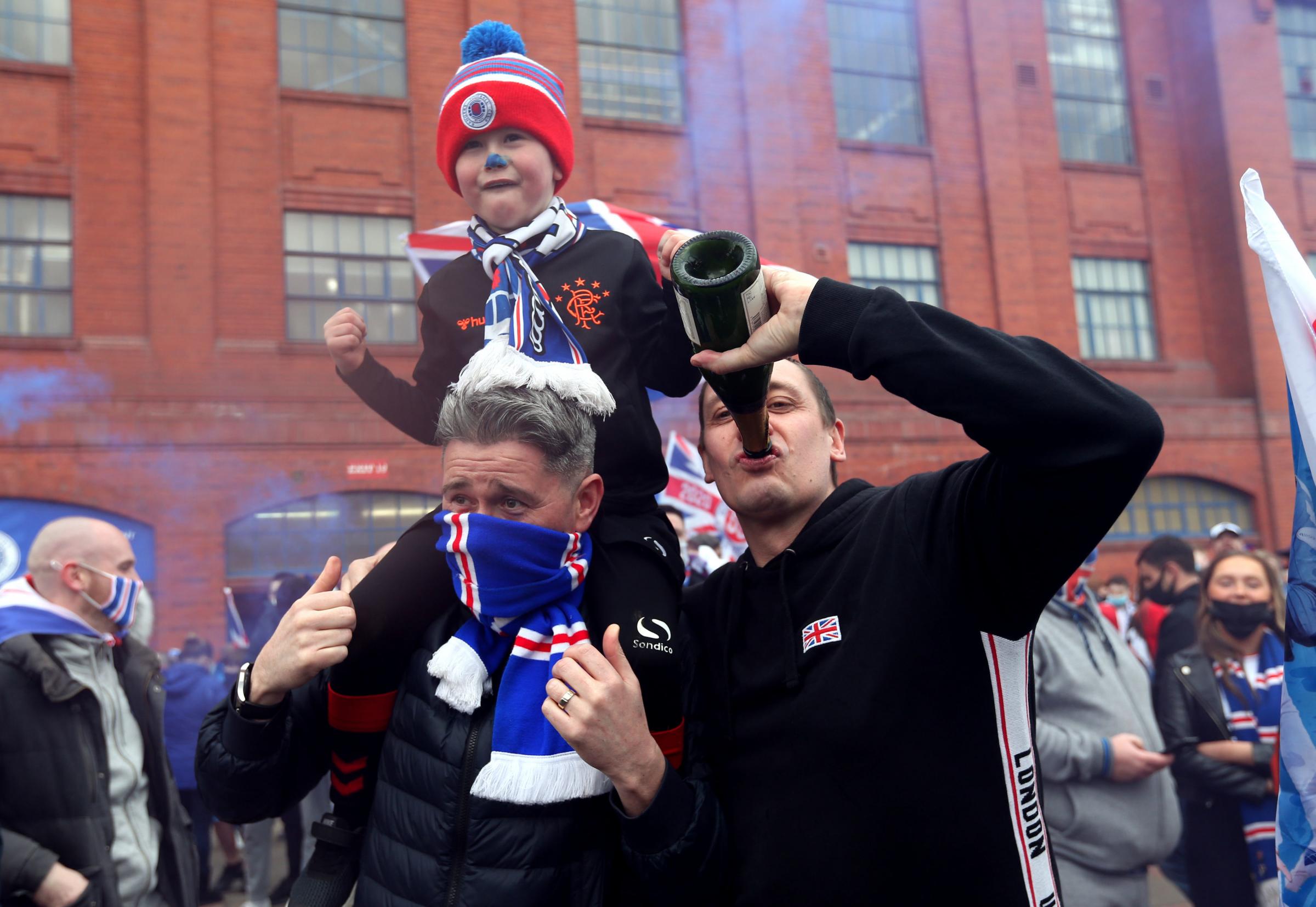 Rangers fans celebrate outside of the Ibrox Stadium after Rangers win the Scottish Premiership title. Picture date: Sunday March 7, 2021. PA Photo. See PA story SOCCER Rangers. Photo credit should read: Robert Perry/PA Wire. 