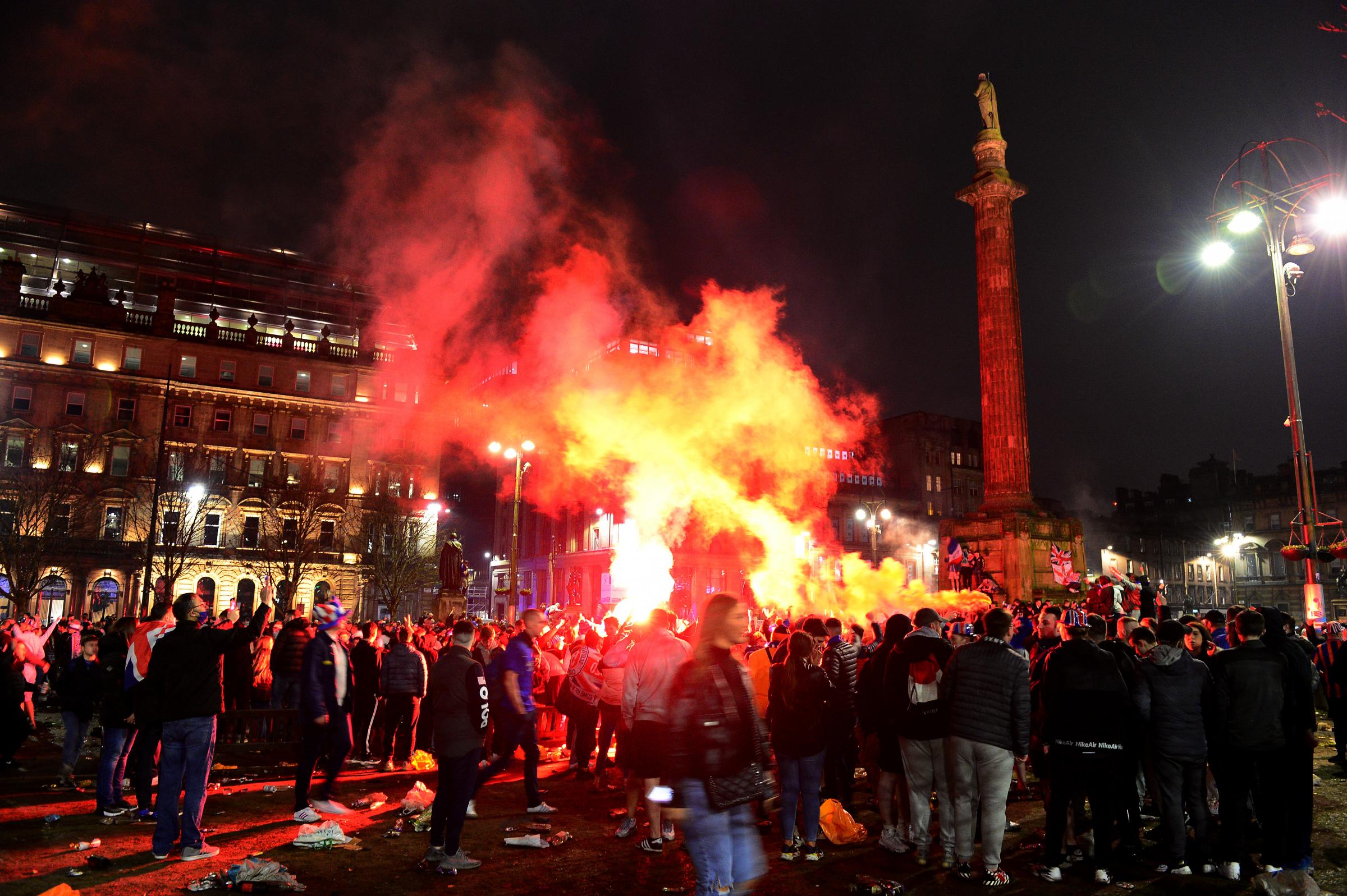 GLASGOW, SCOTLAND - MARCH 07: Rangers fans stand on the monument as they set off flares in George Square to celebrate their team winning the Scottish Premiership title on March 07, 2021 in Glasgow, Scotland. (Photo by Mark Runnacles/Getty Images).