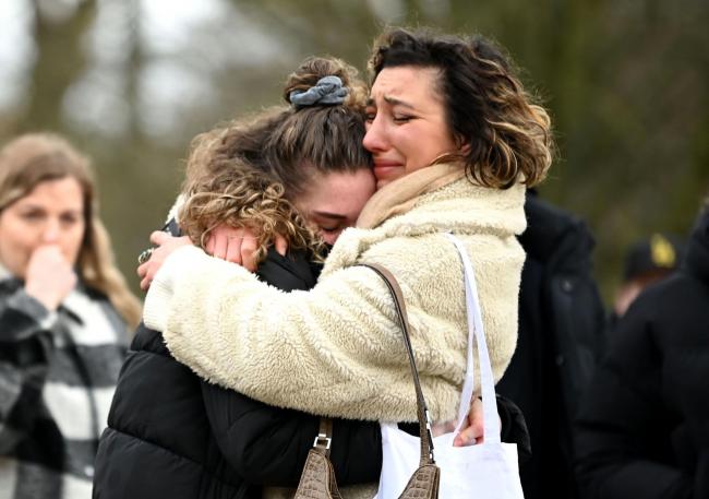 Two women embrace as they stand before tributes for Sarah Everard at the bandstand on Clapham Common in London at the weekend