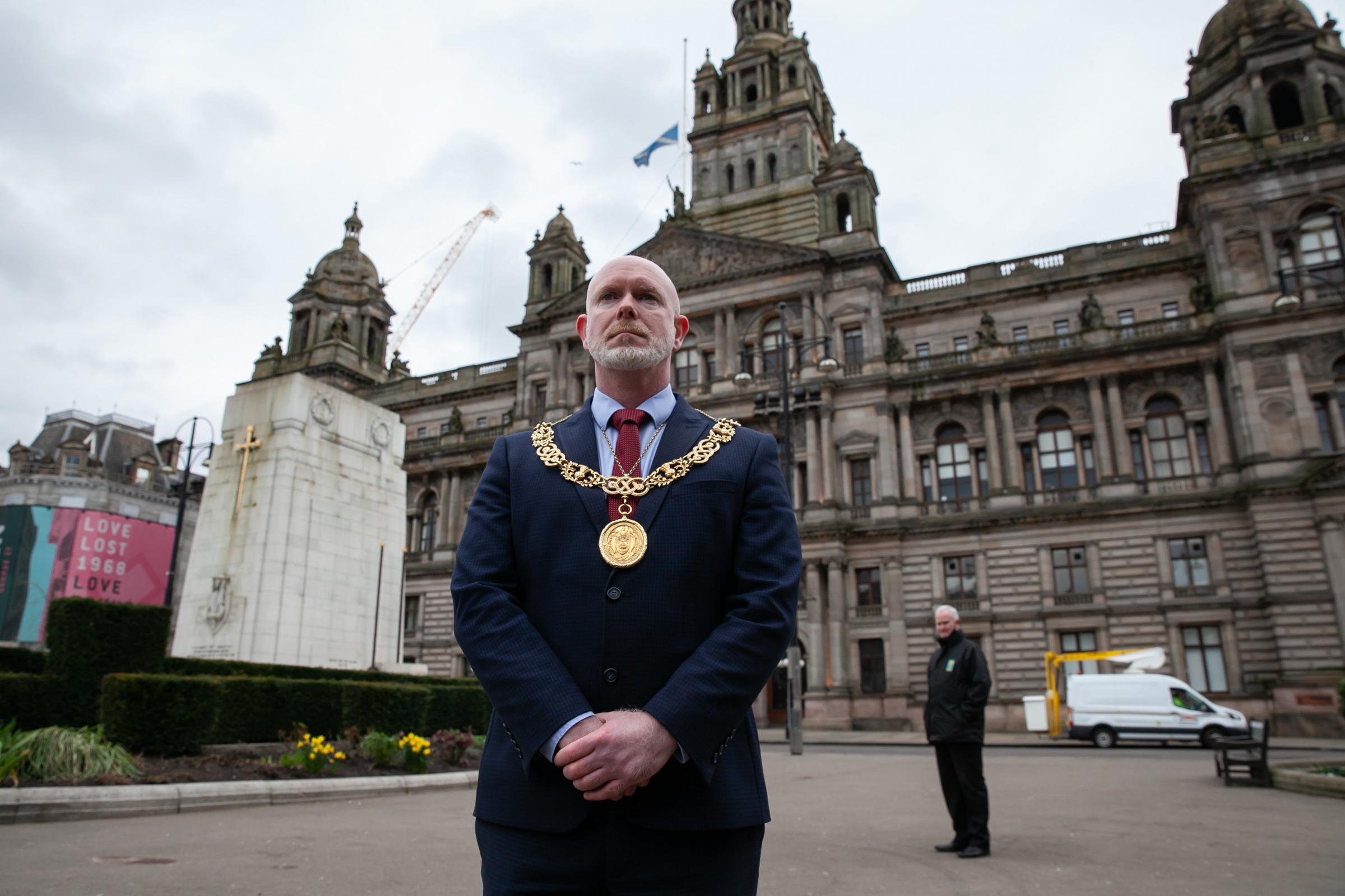 Lord Provost of Glasgow Cllr Philip Braat observes a minutes silence at midday on Tuesday 23rd March to mark the first anniversary of Covid Lockdown. The flag on the City Chambers is at half mast. Photograph by Colin Mearns.