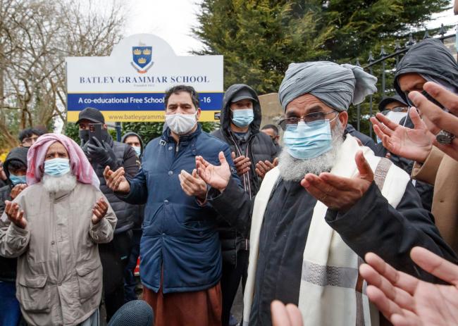 Protesters take part in a prayer outside Batley Grammar School in Batley, West Yorkshire, where a teacher has been suspended for reportedly showing a caricature of the Prophet Mohammed to pupils during a religious studies lesson.