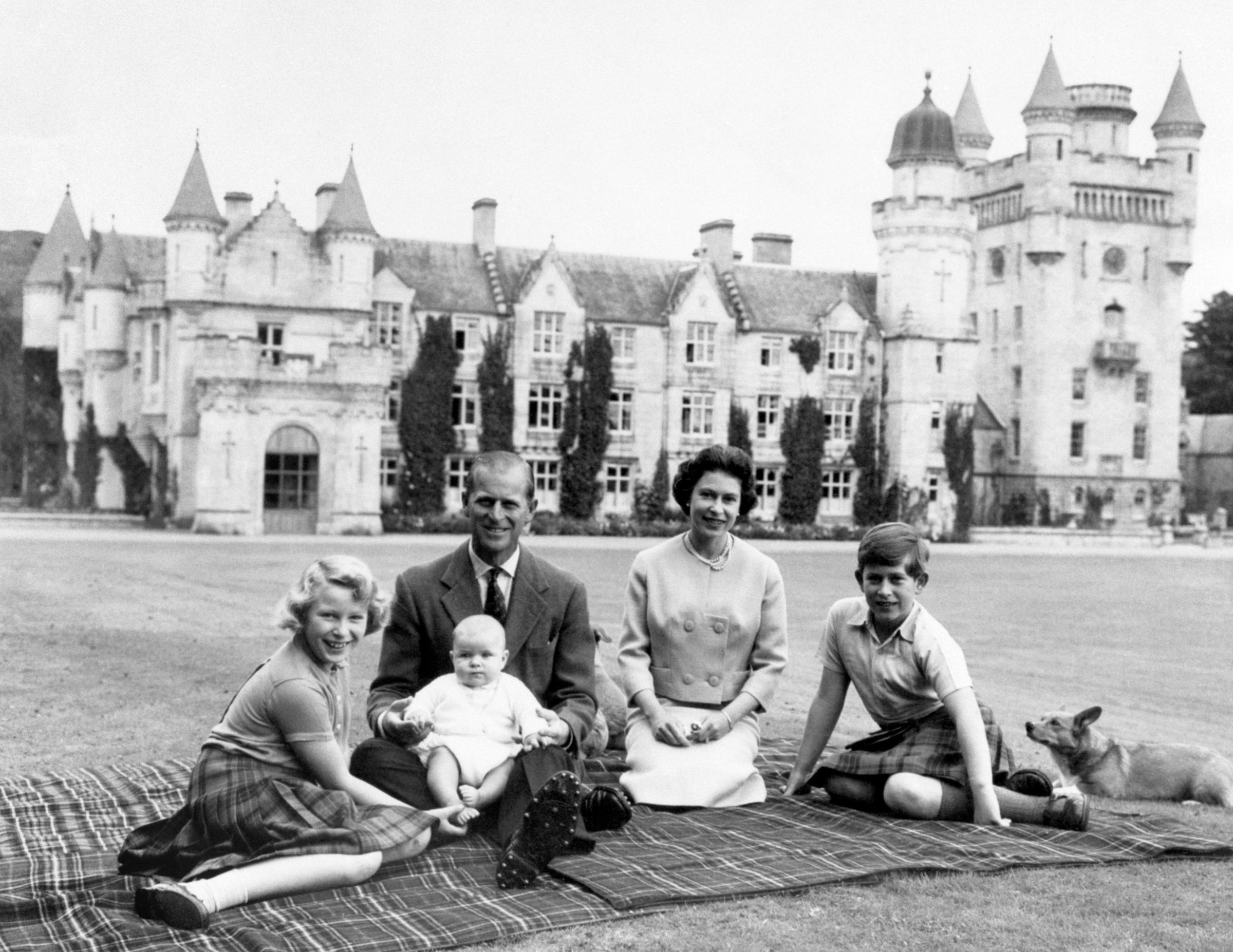 The Queen, the Duke of Edinburgh and three of their children Princess Anne, Prince Charles and baby Prince Andrew, on his fathers knees on the lawns at Balmoral. 
