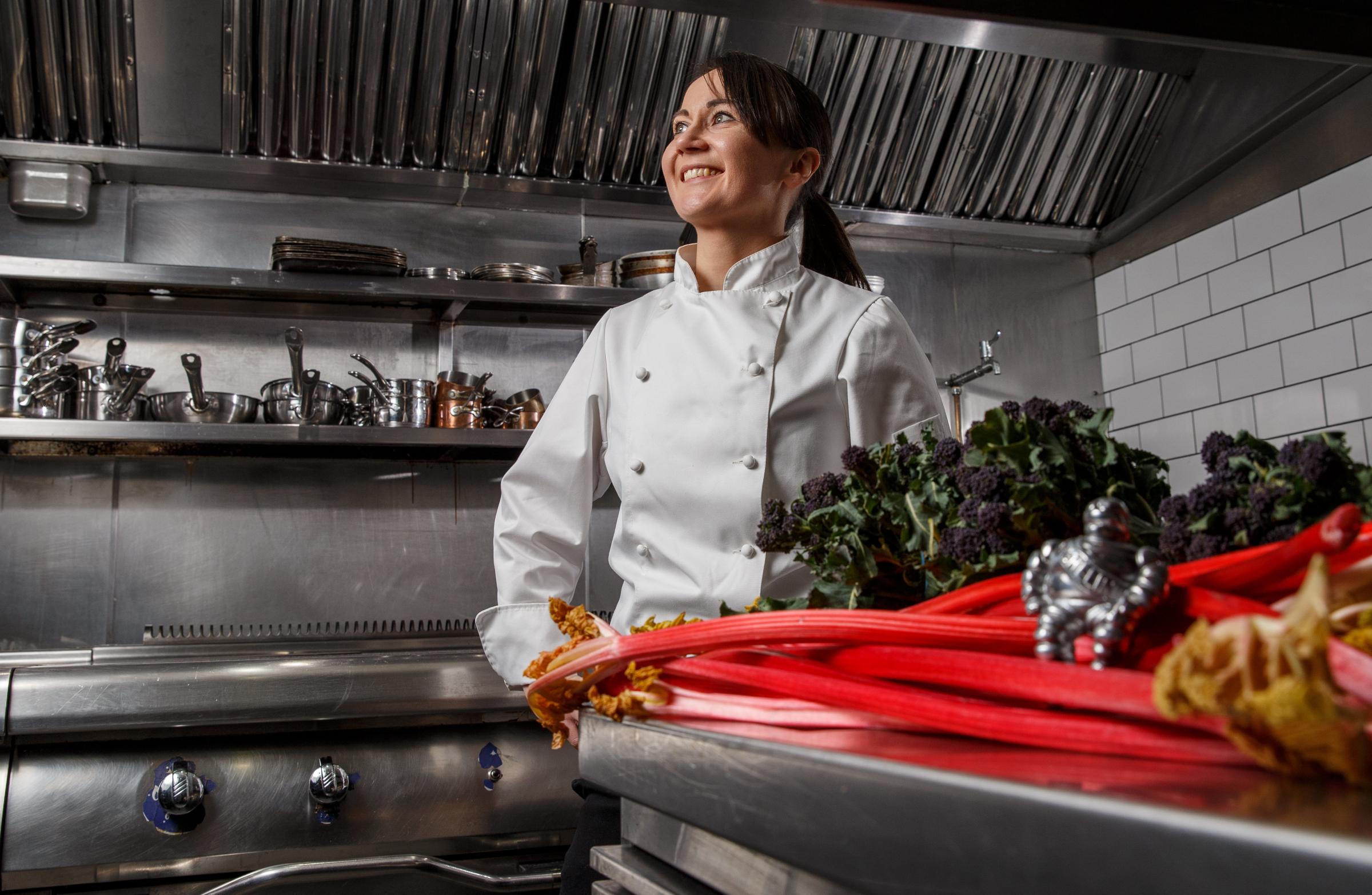 Cail Bruich head chef Lorna McNee pictured in the kitchen at the restaurant. Sitting on the rhubarb is a model of Bibendum (aka the Michelin Man) that she purchased when she discovered that she had been awarded a Michelin star. Photograph by Colin