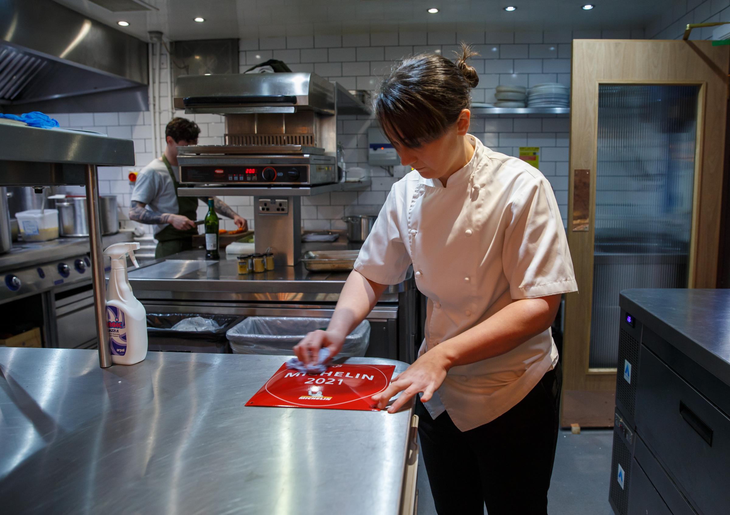 Cail Bruich head chef Lorna McNee pictured in the kitchen polishing the Michelin star plaque that the restaurant received. Photograph by Colin Mearns.