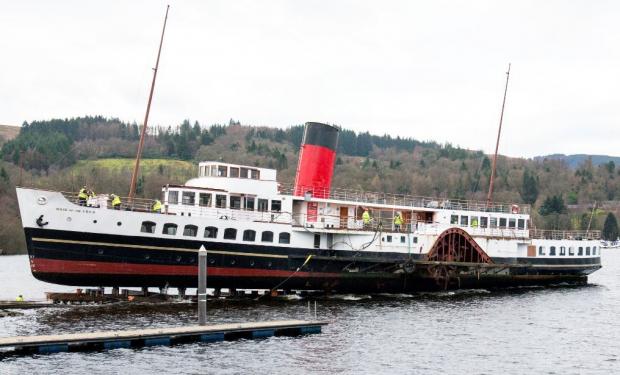 HeraldScotland: The Maid was winched out of Loch Lomond for a hull survey in 2019 - but with hundreds of people watching on, the cradle on which the ship was sitting failed and she slid back into the water