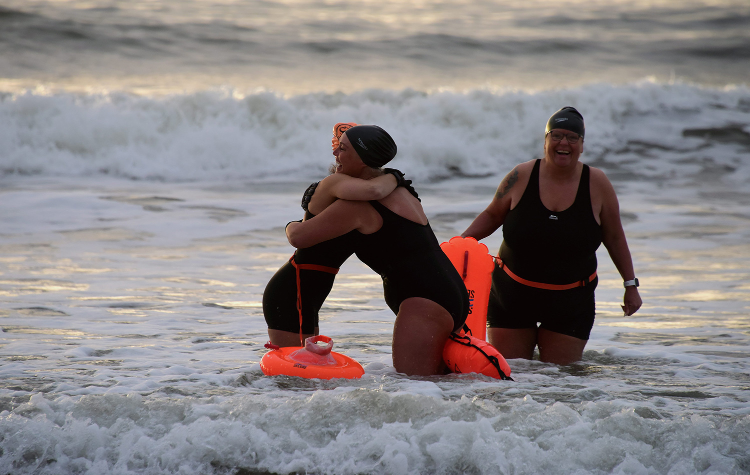 Early morning swimmers greet each other with hugs on Seaburn beach in Sunderland as covid restrictions are lifted 