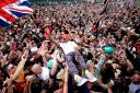 
Mercedes' Lewis Hamilton celebrates with fans after winning the British Grand Prix at Silverstone, Towcester. PRESS ASSOCIATION Photo. Picture date: Sunday July 14, 2019. See PA story AUTO British. Photo credit should read: David Davies/PA Wire. REST