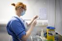 Nurse Eleanor Pinkerton prepares a coronavirus vaccine to be given to a health and care staff member at the NHS Louisa Jordan Hospital in Glasgow in 2021