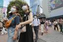 People wearing face masks to protect against the spread of the coronavirus walk on a street in Tokyo Wednesday, July 28, 2021.  (AP Photo/Koji Sasahara).