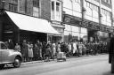 Shoppers queue outside a butchers and pie shop (c 1950)