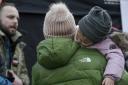 A woman holds a sleeping child, at a border crossing, as refugees flee Ukraine, in Medyka, Poland, Thursday, March 3, 2022. The U.N. refugee agency said Thursday at least 1 million people have fled Ukraine since Russia's invasion a week ago, an