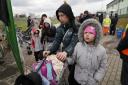 Refugees walk after fleeing the war from neighbouring Ukraine at the border crossing in Medyka, southeastern Poland, Sunday, April 3, 2022. (AP Photo/Sergei Grits)