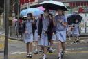 Primary school students wearing face masks walk along a street in Hong Kong, Tuesday, April 19, 2022. Students resumed face-to-face classes after suspended for nearly three months amid a fifth wave of coronavirus infections. Teachers and students were