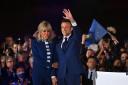 Emmanuel Macron and his wife Brigitte Macron acknowledge voters in front of the Eiffel Tower, Paris after after giving a speech after beating his far-right rival Marine Le Pen for a second five-year term as president. Photo Getty.