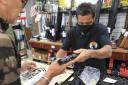 A clerk hands a gun to a customer inside a gun shop, Thursday, June, 23, 2022 in Honolulu. In a major expansion of gun rights after a series of mass shootings, the Supreme Court said Thursday that Americans have a right to carry firearms in public for
